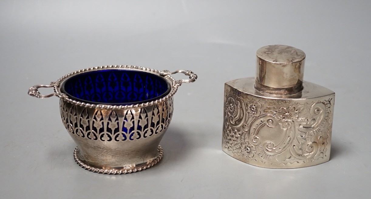A late Victorian repousse silver tea caddy, Birmingham, 1899, height, 86mm and a later silver two handled sugar bowl with blue glass liner.